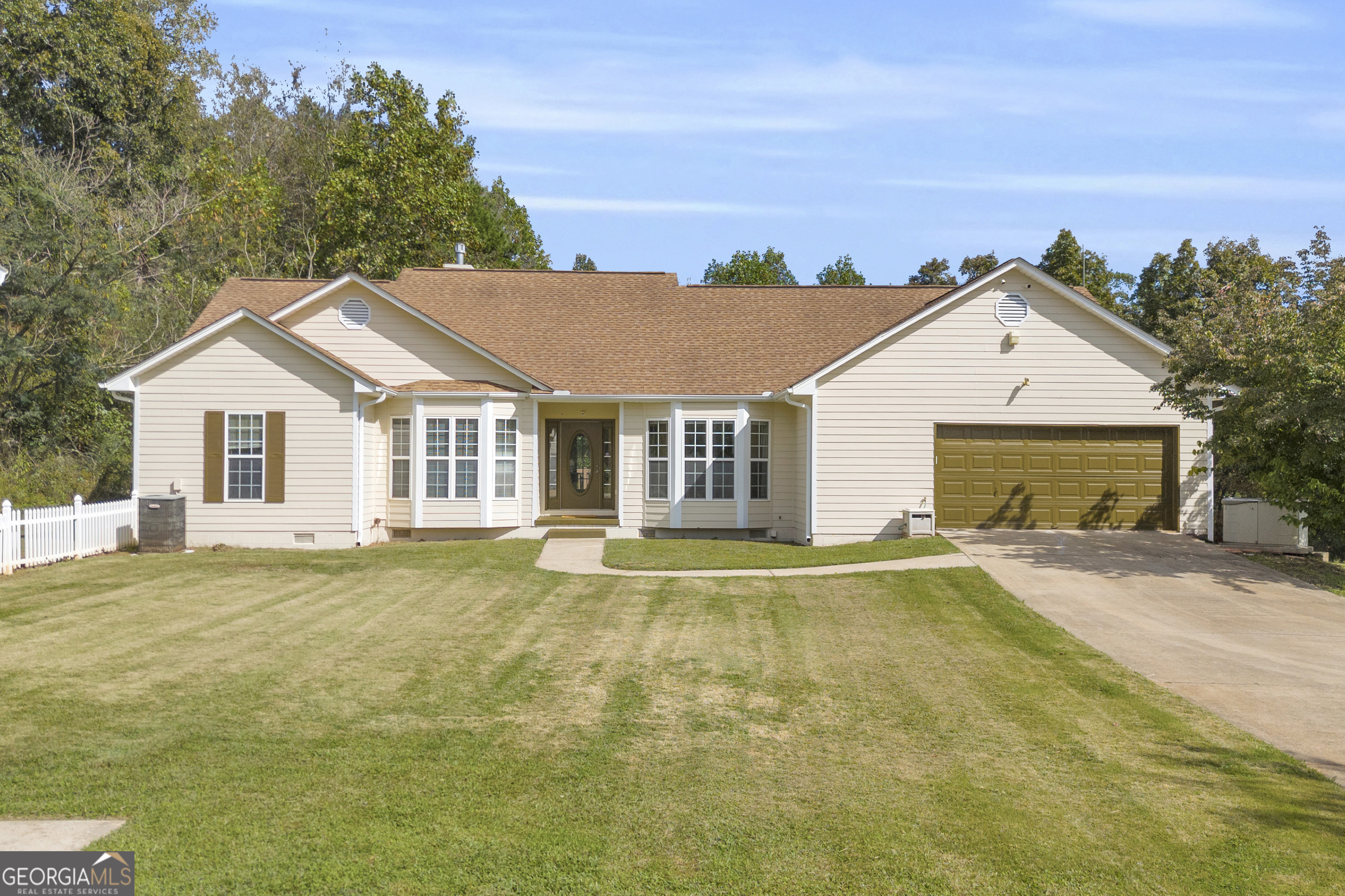 a view of a yard in front of a house with a large tree