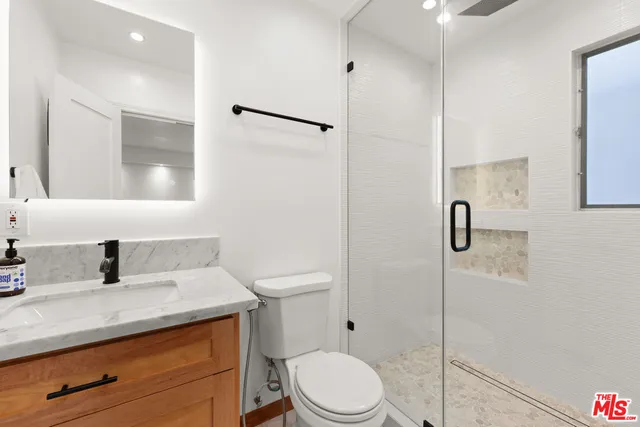 a bathroom with a sink a toilet and shower