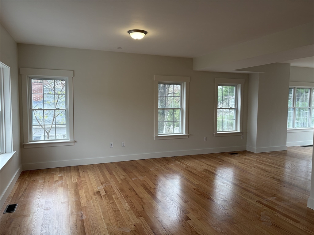 76 Valmor Street Worcester, MA 01604 - Photo 9 of 20 an empty room with wooden floor and windows