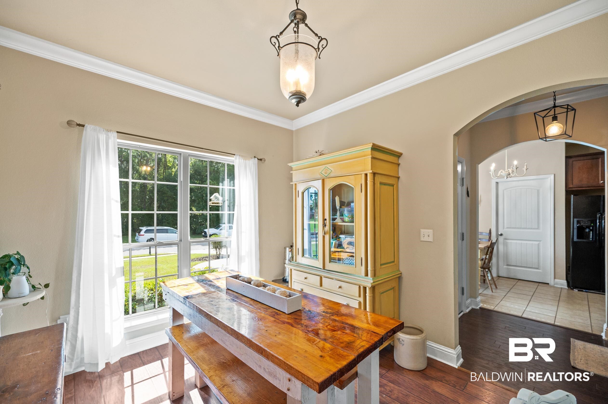 745 Bonaventure Street Fairhope, AL 36532 - Photo 11 of 36 Dining area featuring ornamental molding, dark wood-type flooring, and a notable chandelier