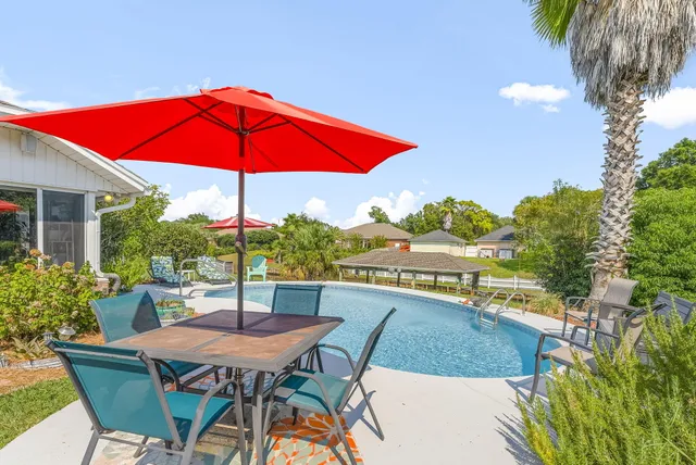 a view of a house with swimming pool and a yard