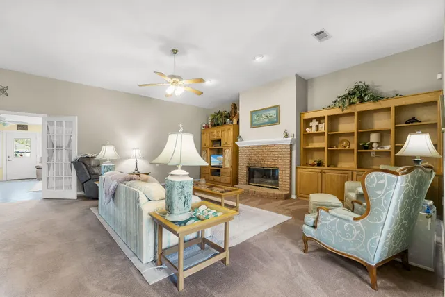 a living room with furniture a fireplace and a chandelier