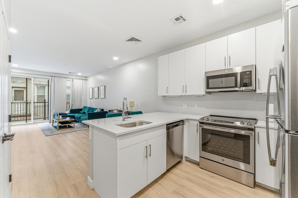 157 Chestnut Street, Unit 203 Chelsea, MA 02150 - Photo 1 of 31 a kitchen with a stove a sink and a microwave