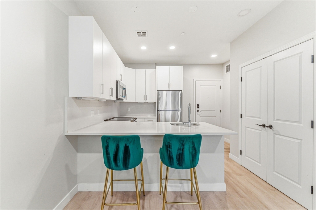 157 Chestnut Street, Unit 203 Chelsea, MA 02150 - Photo 2 of 31 a kitchen with a sink and chairs