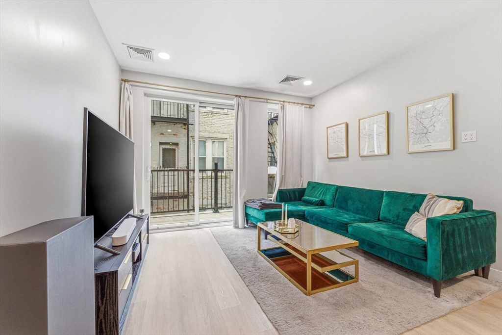 157 Chestnut Street, Unit 203 Chelsea, MA 02150 - Photo 7 of 31 a living room with furniture and a flat screen tv