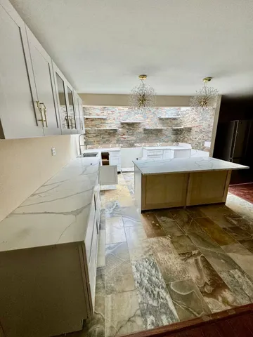 a living room with stainless steel appliances kitchen island granite countertop furniture and a fireplace