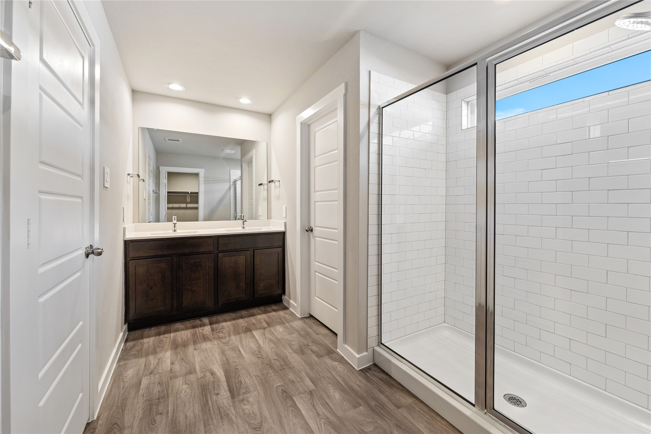 12722 Basinghall Lane Houston, TX 77047 - Photo 12 of 22 a bathroom with a vanity a sink a mirror and a shower