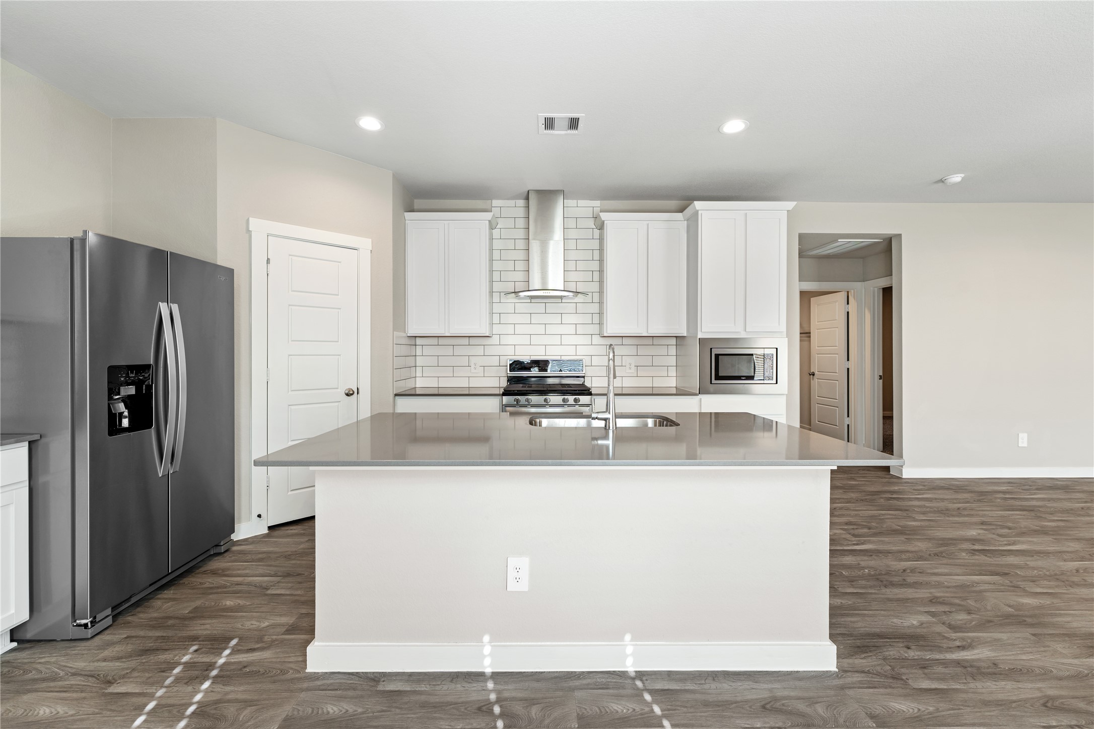12722 Basinghall Lane Houston, TX 77047 - Photo 8 of 22 a view of a kitchen with kitchen island white cabinets and stainless steel appliances
