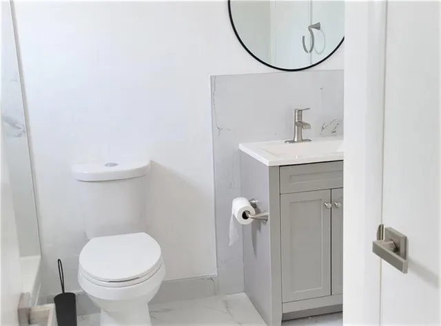 a bathroom with a sink a toilet and a mirror