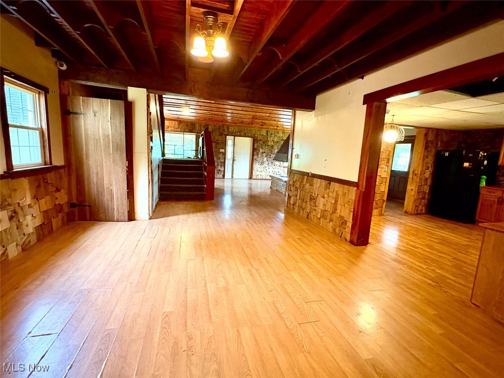 82755 Laughlin Road Tippecanoe, OH 44699 - Photo 25 of 35 Dining room featuring wainscoting, wood finished floors, stairs, and wooden walls