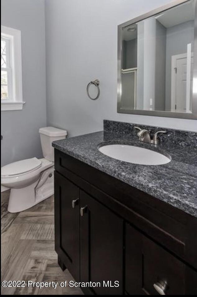 129 Wellington Road Shavertown, PA 18708 - Photo 9 of 16 a bathroom with a granite countertop sink a toilet and mirror