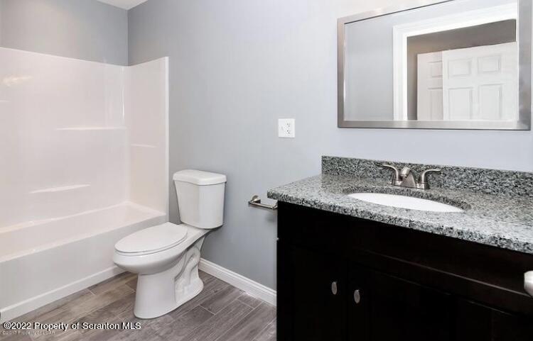129 Wellington Road Shavertown, PA 18708 - Photo 10 of 16 a bathroom with a granite countertop toilet a sink and a mirror