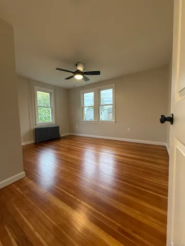 a view of a livingroom with wooden floor and window