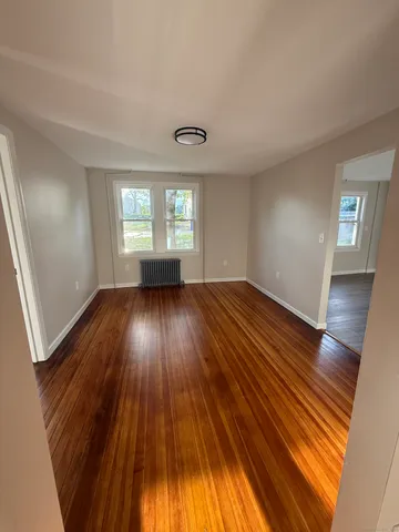 wooden floor in an empty room with a window