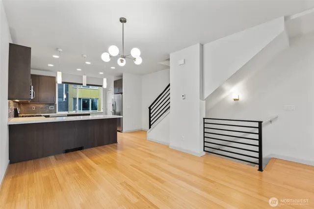 a kitchen with granite countertop stainless steel appliances a large counter top space cabinets and wooden floor