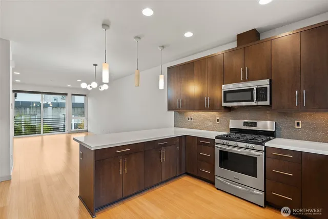 a kitchen with granite countertop a refrigerator a oven and a sink