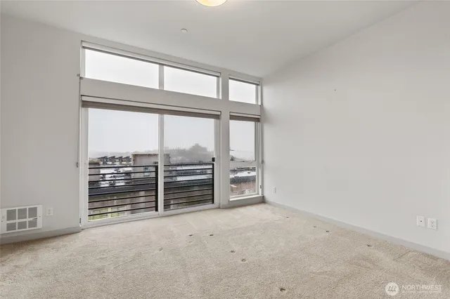 an empty room with floor to ceiling windows and city view