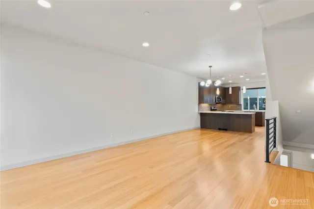 a view of a kitchen with kitchen island a sink wooden floor and a counter top space