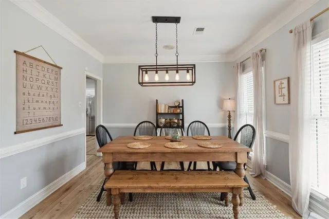 a view of a a dining room with furniture window and wooden floor