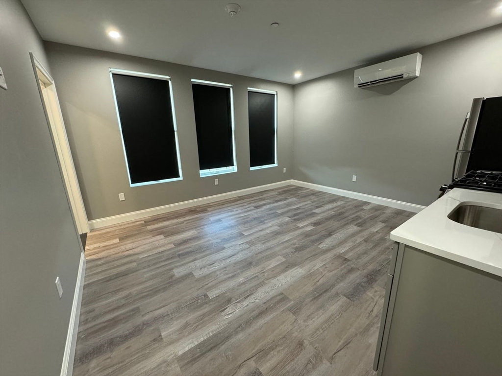 55 Walnut Avenue, Unit 103 Revere, MA 02151 - Photo 4 of 7 a view of an empty room with wooden floor and a window