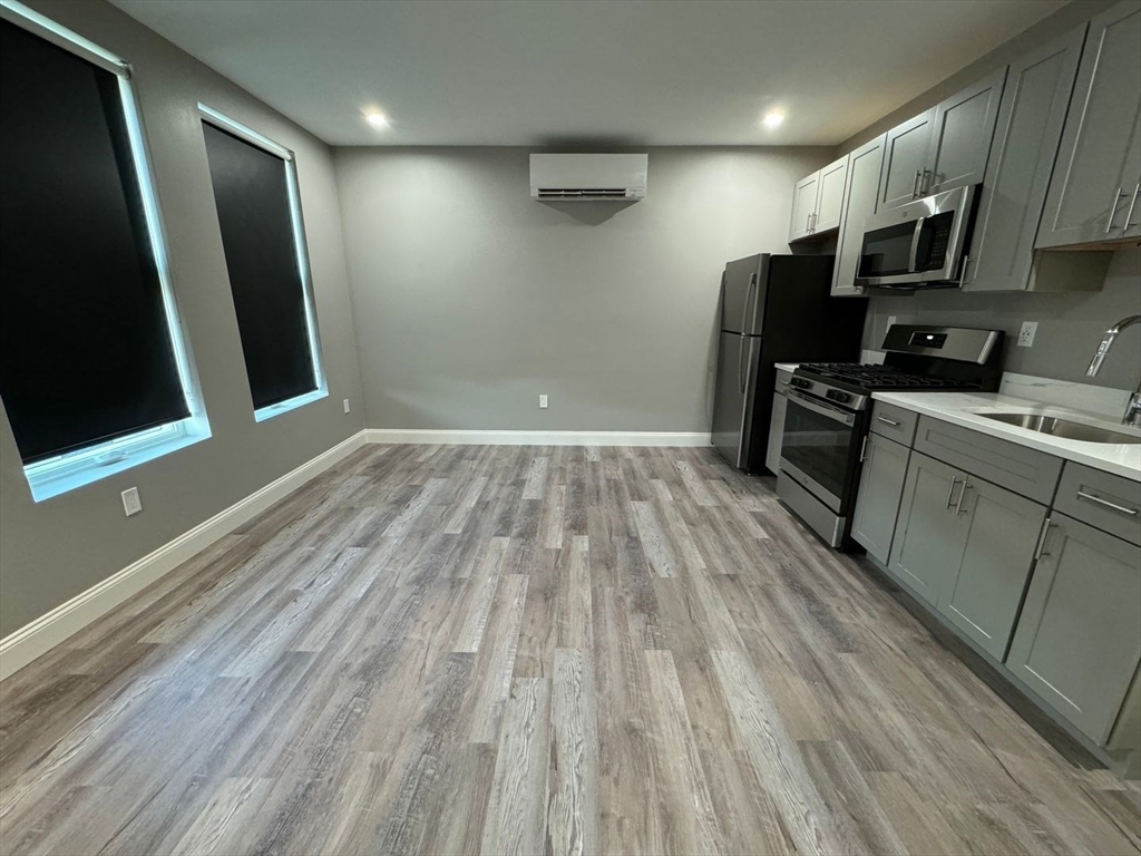 55 Walnut Avenue, Unit 103 Revere, MA 02151 - Photo 6 of 7 a view of a kitchen with wooden floor and electronic appliances