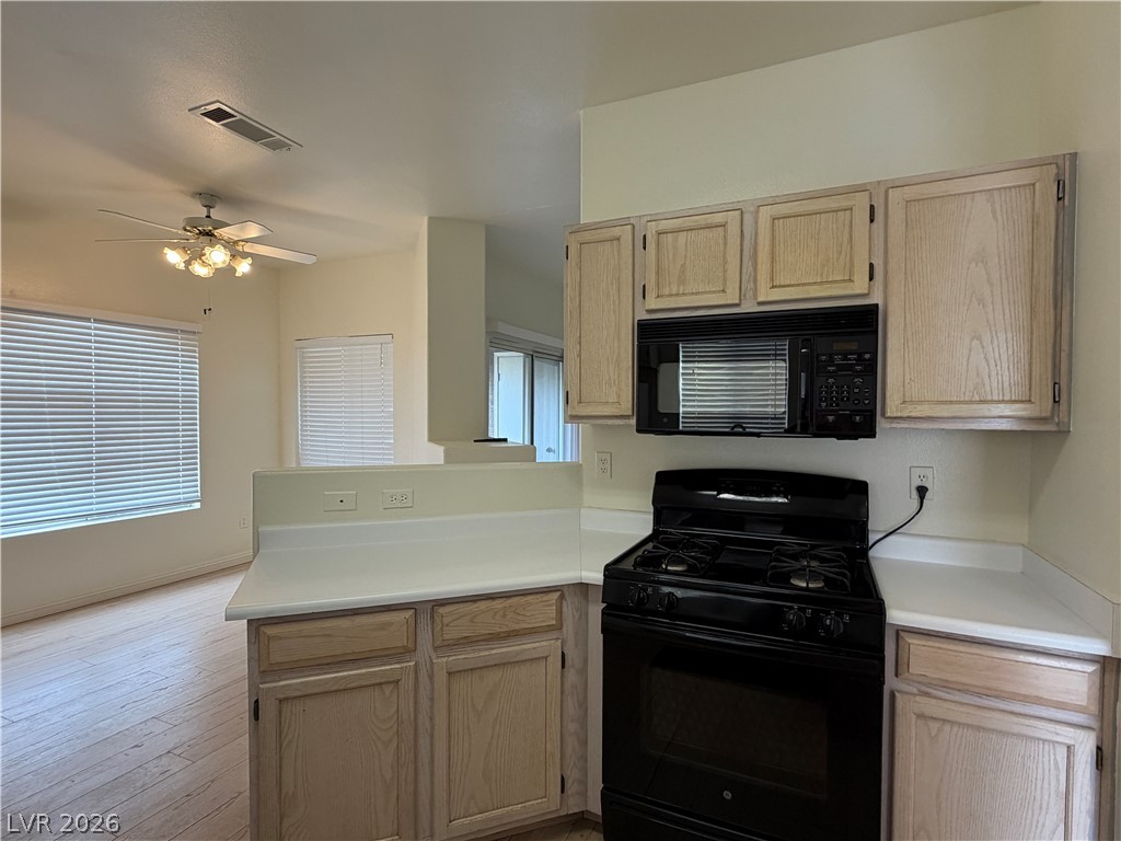 5525 West Flamingo Road, Unit 2016 Las Vegas, NV 89103 - Photo 8 of 20 Kitchen with light wood finish cabinets, black appliances, light countertops, and a ceiling fan