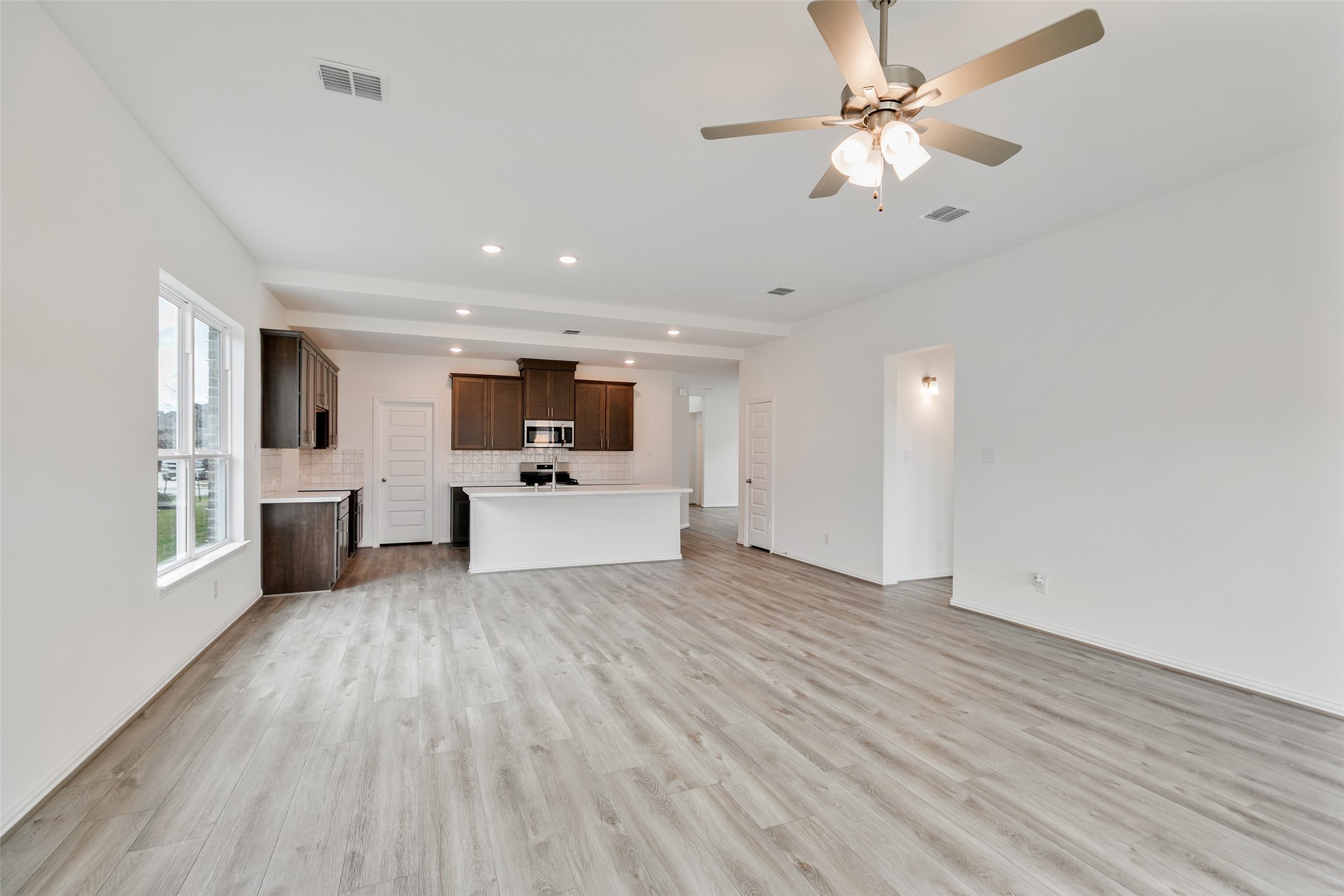 2710 Alexis Street Seabrook, TX 77586 - Photo 20 of 46 a view of a kitchen with furniture wooden floor and a ceiling fan