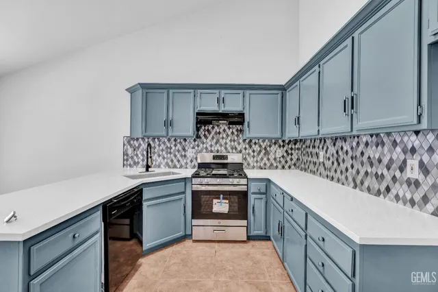 a kitchen with a stove sink and cabinets