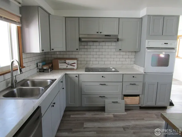 a kitchen with cabinets appliances a sink and a counter space