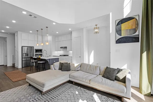 a living room with furniture a lamp and large window