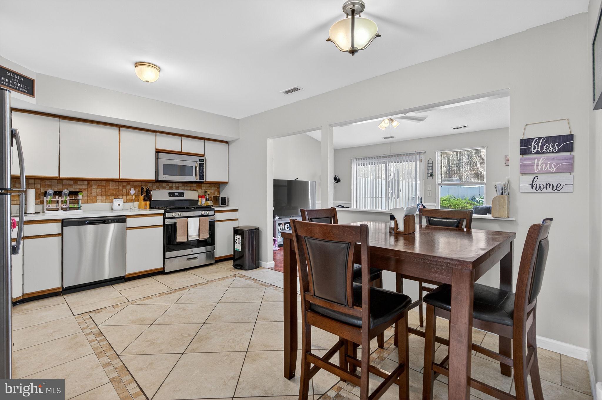 147 Baker Avenue Atco, NJ 08004 - Photo 8 of 31 a kitchen with stainless steel appliances kitchen island granite countertop a stove a sink a dining table and chairs