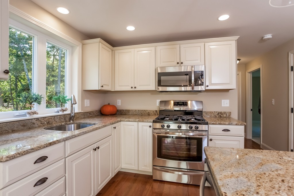 a kitchen with granite countertop a stove a sink and a granite counter tops