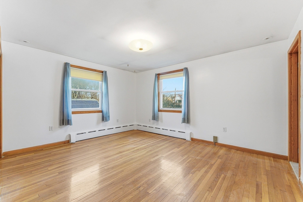 7 Carol Street Stoneham, MA 02180 - Photo 14 of 28 an empty room with wooden floor and windows