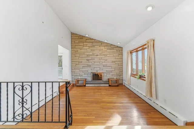 a view of a livingroom with wooden floor and furniture