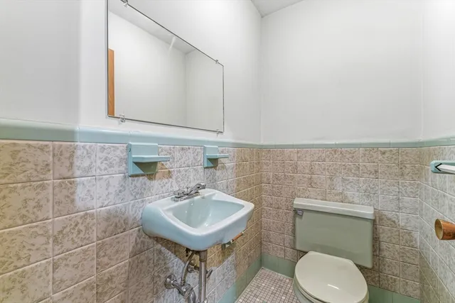 a bathroom with a sink a toilet and mirror