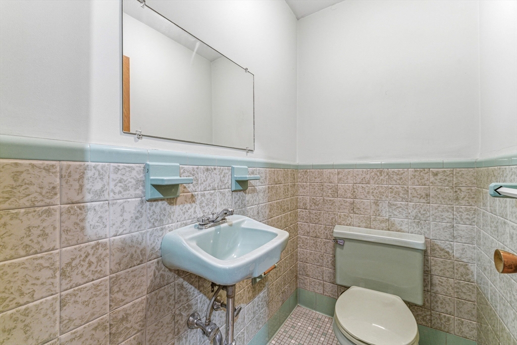 7 Carol Street Stoneham, MA 02180 - Photo 21 of 28 a bathroom with a sink a toilet and mirror