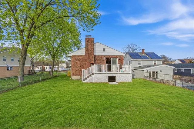 a white house with a big yard and large trees