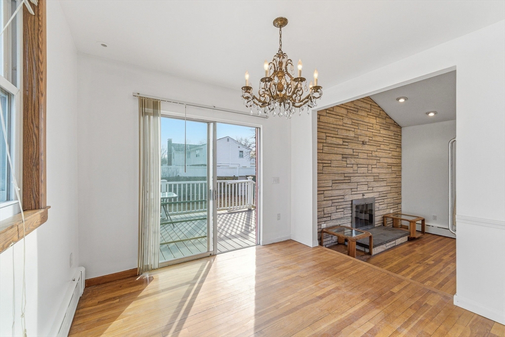 7 Carol Street Stoneham, MA 02180 - Photo 8 of 28 a view of a livingroom with a chandelier a ceiling fan and windows