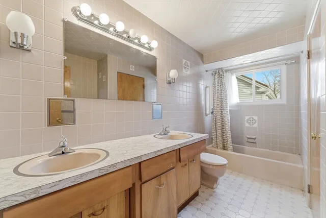 a bathroom with a sink double vanity granite tub and a mirror