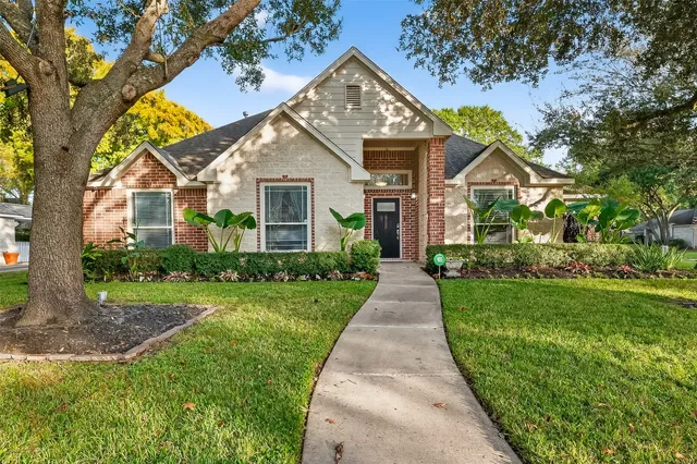a front view of a house with a yard and trees