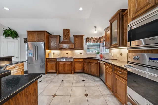 a kitchen with stainless steel appliances a refrigerator sink and stove
