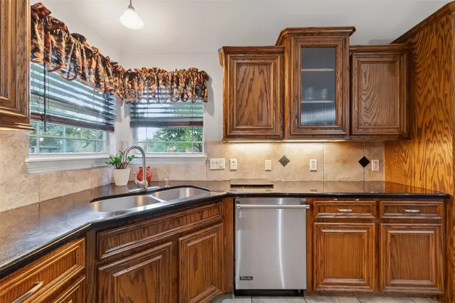 a kitchen with granite countertop a sink and a stove