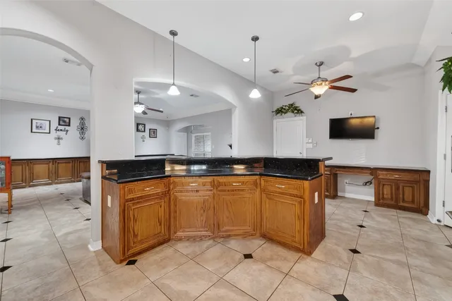 a large kitchen with granite countertop a stove a sink and a microwave
