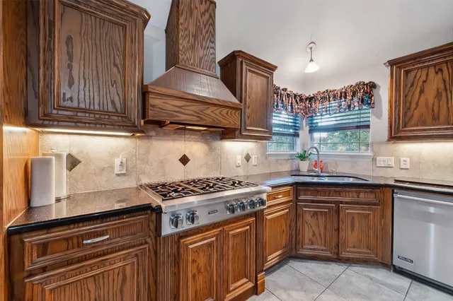 a kitchen with granite countertop a sink stove and cabinets