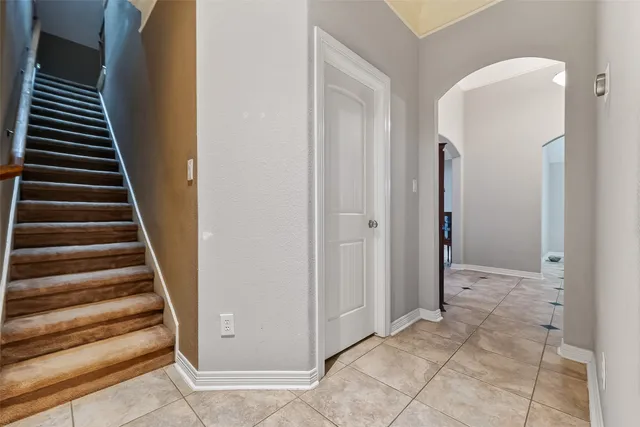 a view of a hallway with entryway and white walls