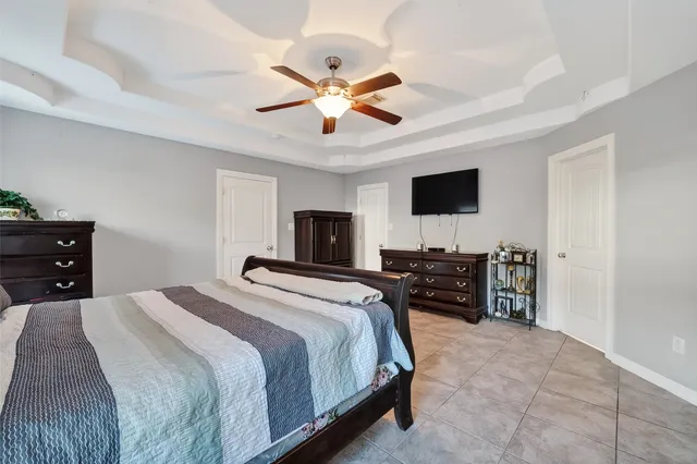 a spacious bedroom with a bed and a chandelier