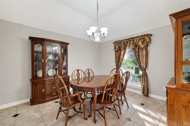 a dining room with furniture a chandelier and window