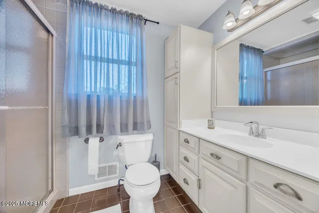 a bathroom with a sink toilet a mirror and shower