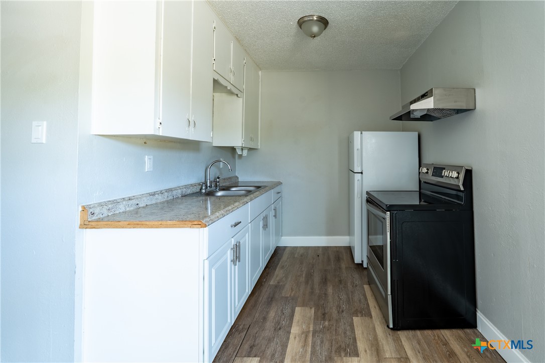 512 Sunset Lane, Unit AD Copperas Cove, TX 76522 - Photo 22 of 23 a kitchen with sink a refrigerator and cabinets