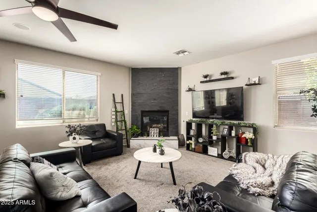 a living room with furniture flat screen tv and a large window